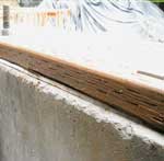 Wood is separated from concrete by a plastic layer
